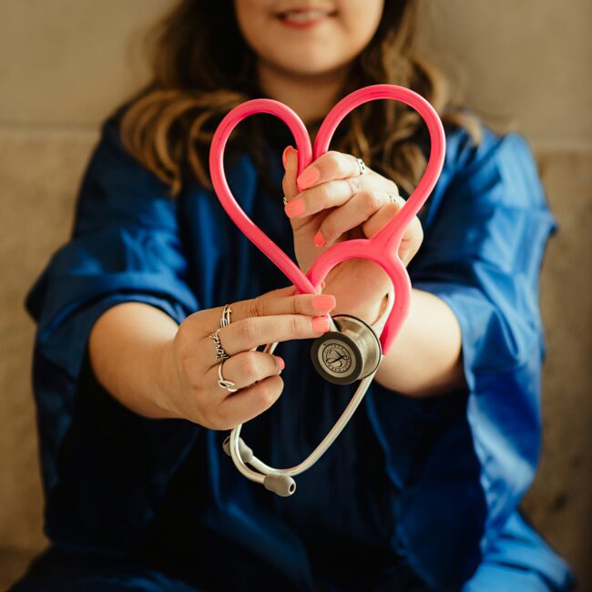 nurse holding a stethoscope in the shape of a heart