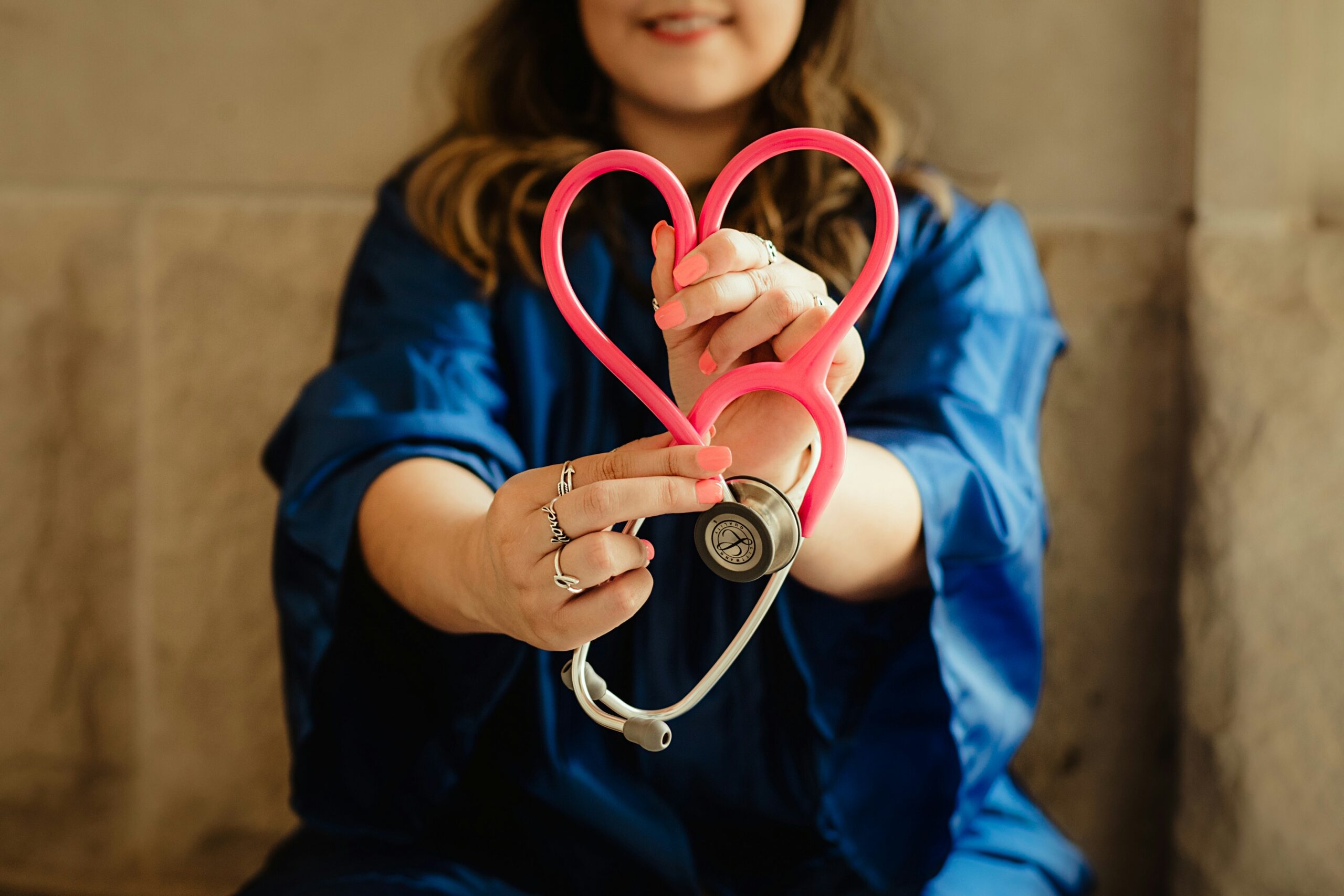 nurse holding a stethoscope in the shape of a heart